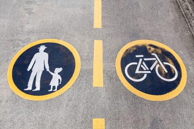 Man with child, and a bicycle painted on a street